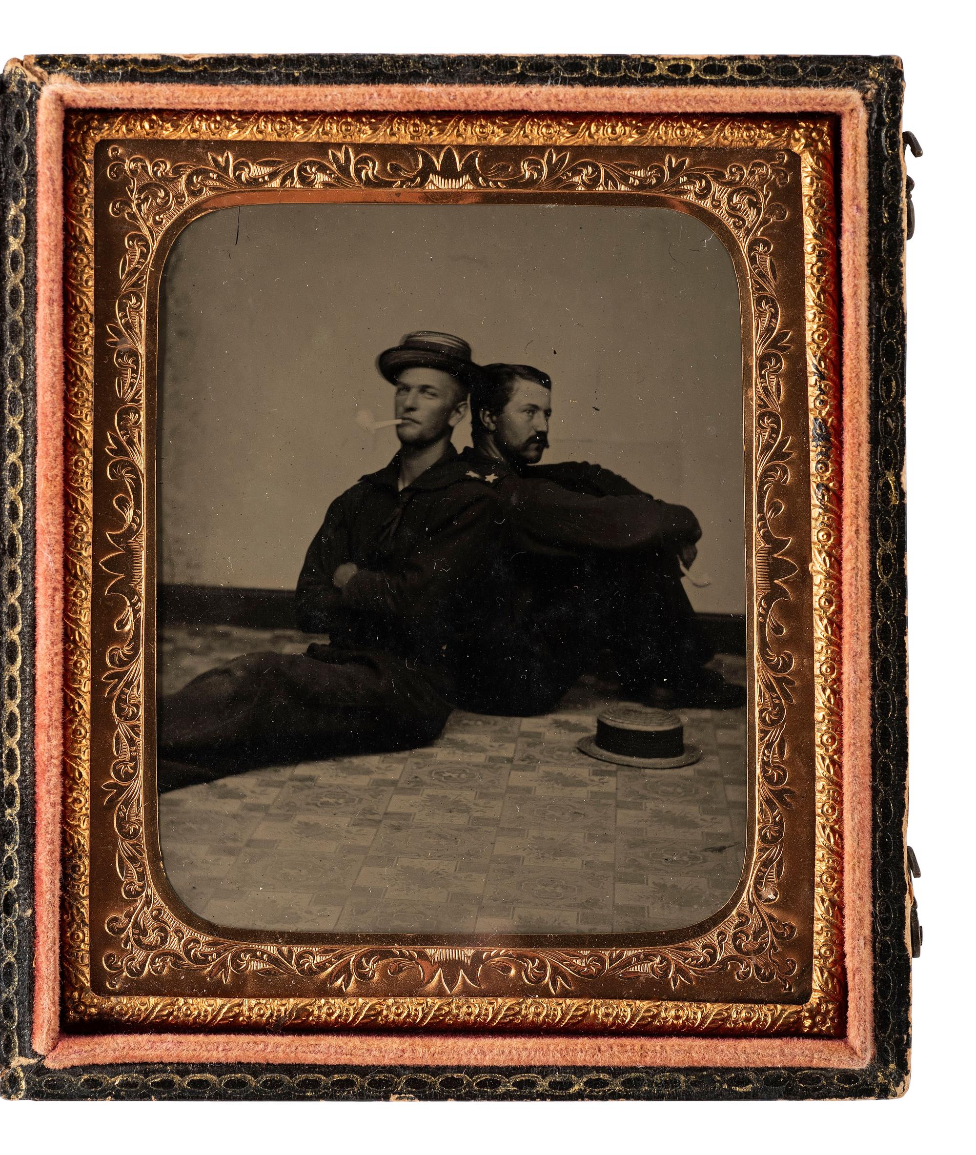 [CIVIL WAR]. Sixth plate tintype of two Union sailors casually sitting back to back on a studio floor.
