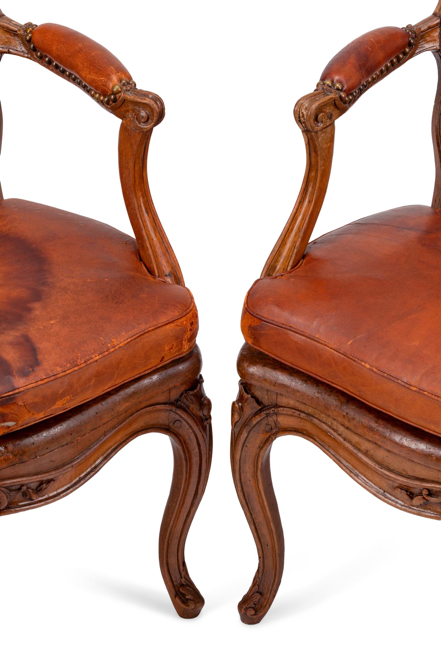 A Pair of Louis XV Beechwood Fauteuils with Cane and Leather Seat Cushions