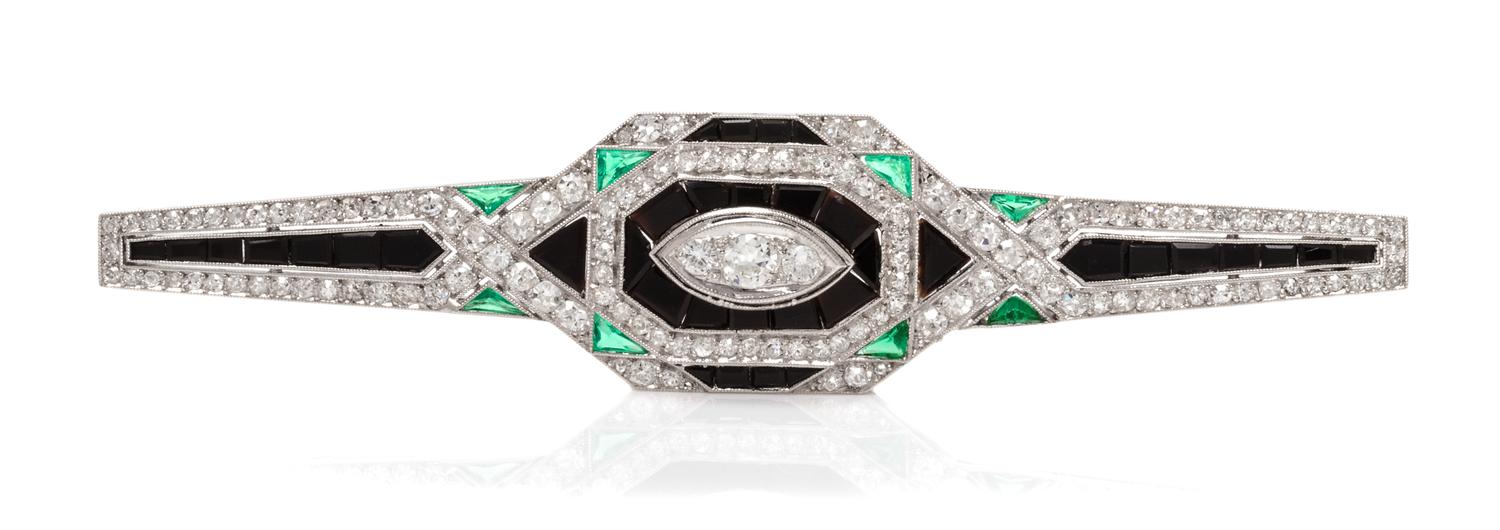 An Art Deco Platinum, Diamond, Onyx and Emerald Bar Brooch, French, 7.40 dwts.
