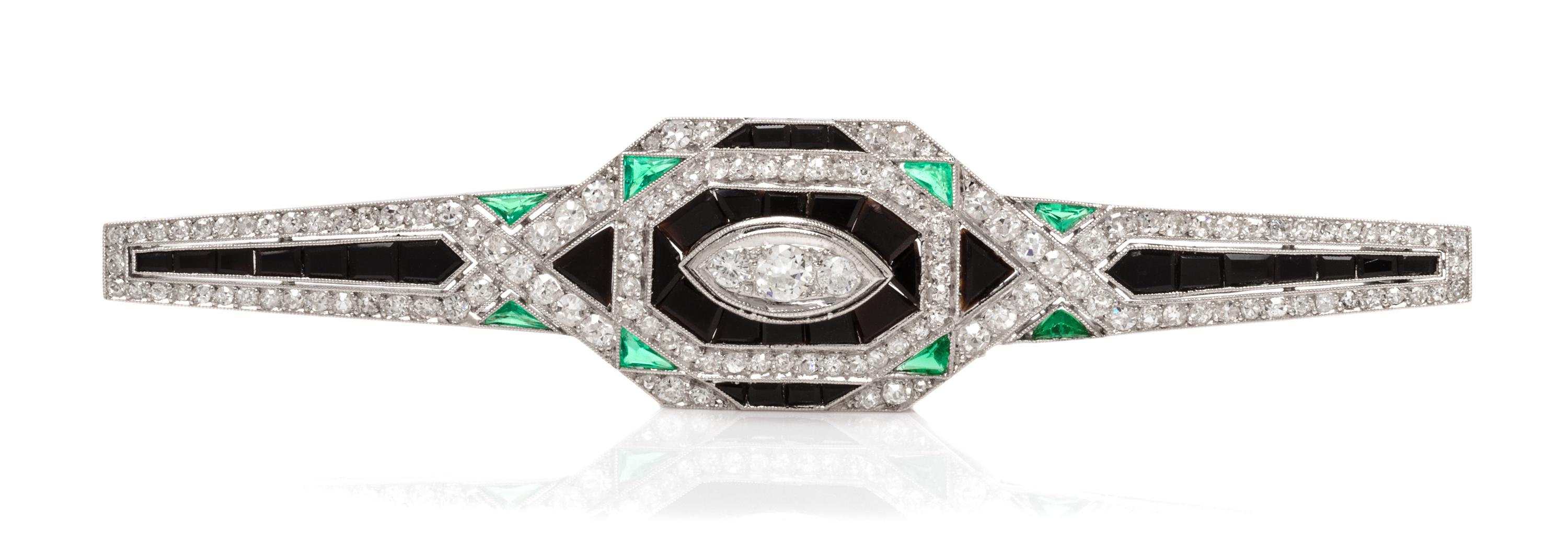 An Art Deco Platinum, Diamond, Onyx and Emerald Bar Brooch, French, 7.40 dwts.