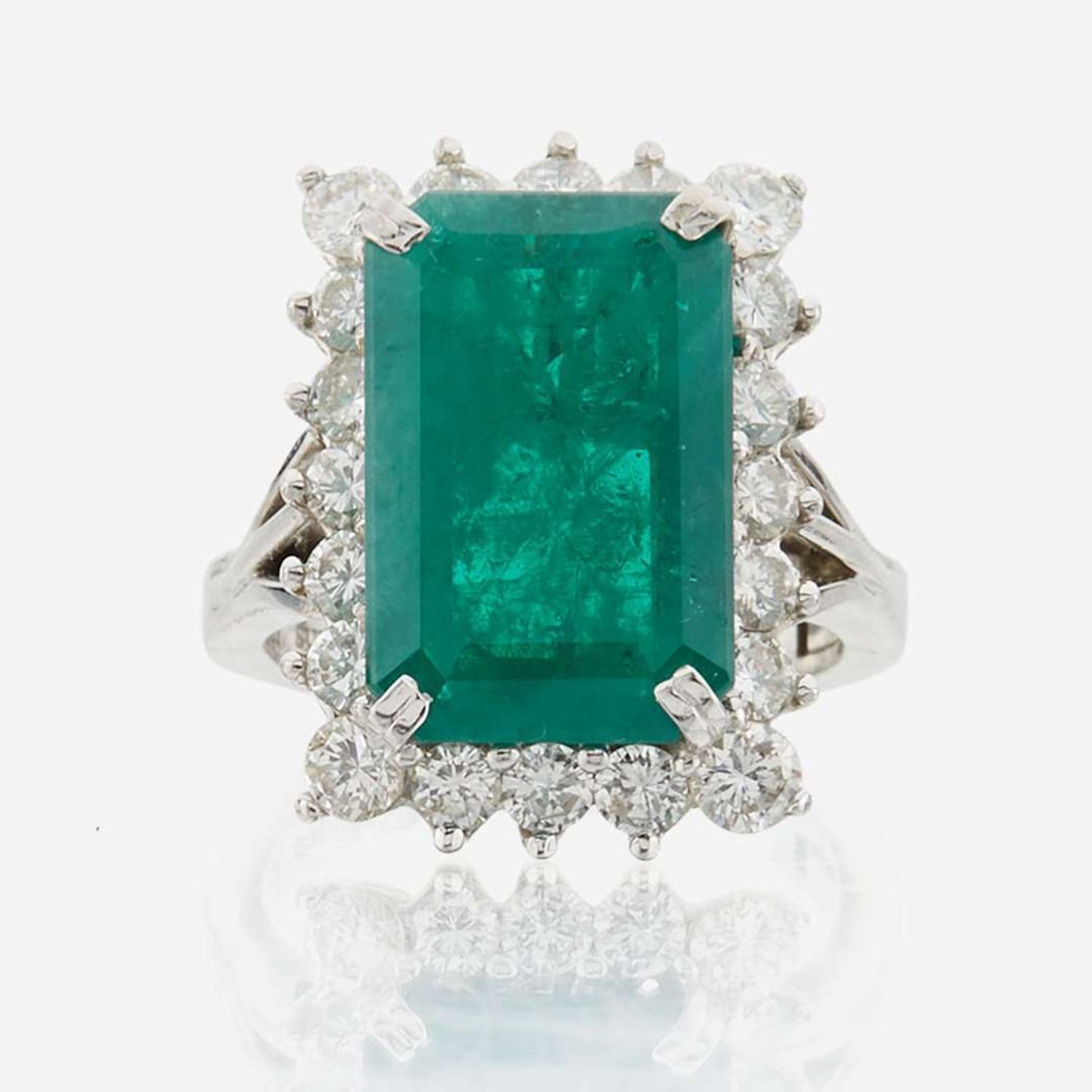 An emerald, diamond, and white gold ring