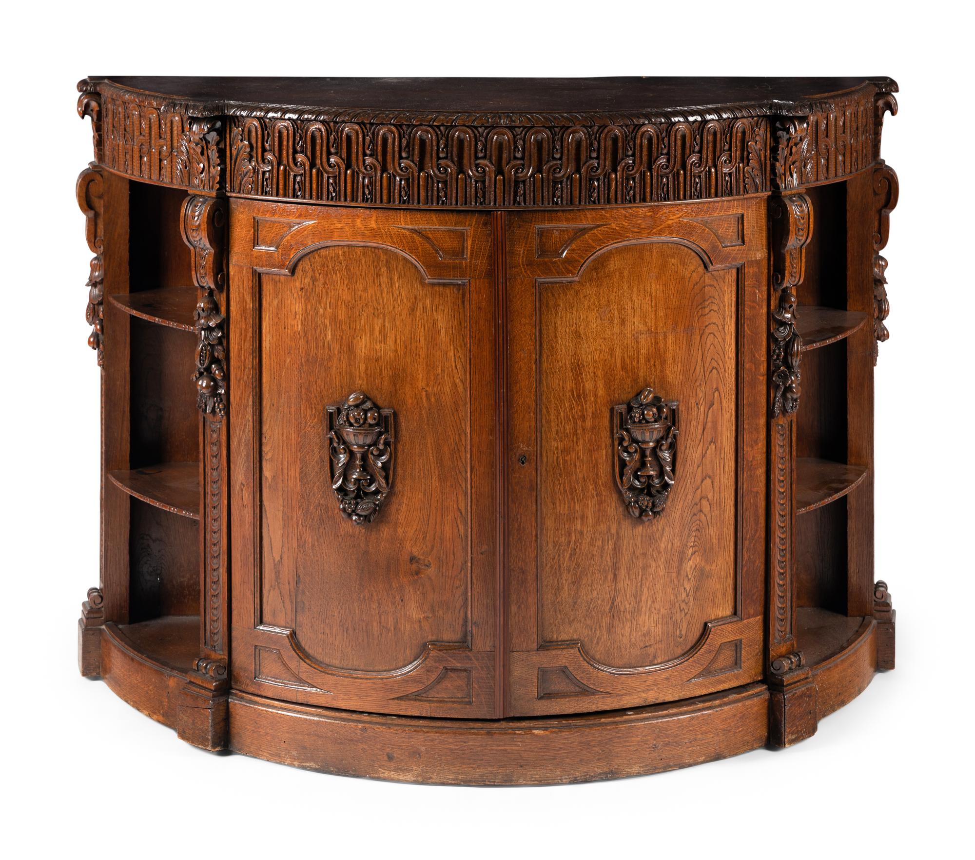 A Continental Carved Oak Demilune Cabinet