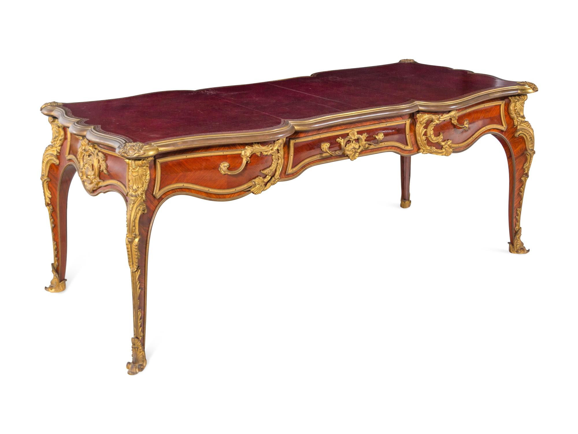 A Louis XV Style Gilt Bronze Mounted and Tooled Leather-Inset Tulipwood Bureau Plat