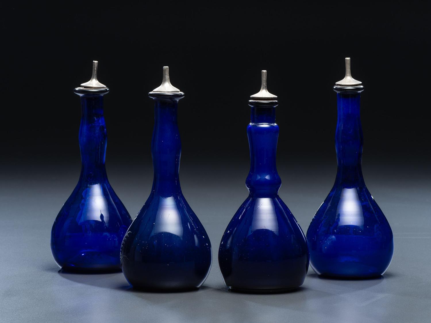 Four 'Mary Gregory' Cobalt Glass Barber Bottles