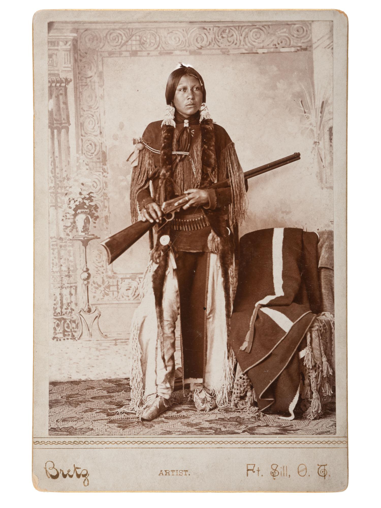 [NATIVE AMERICANS] BRETZ, George. Cabinet card of armed Comanche Indian. Ft. Sill, Oklahoma Terr.