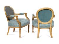 A Pair of Louis XVI Style Cream-Painted and Parcel Gilt Fauteuils with Needlepoint Backs