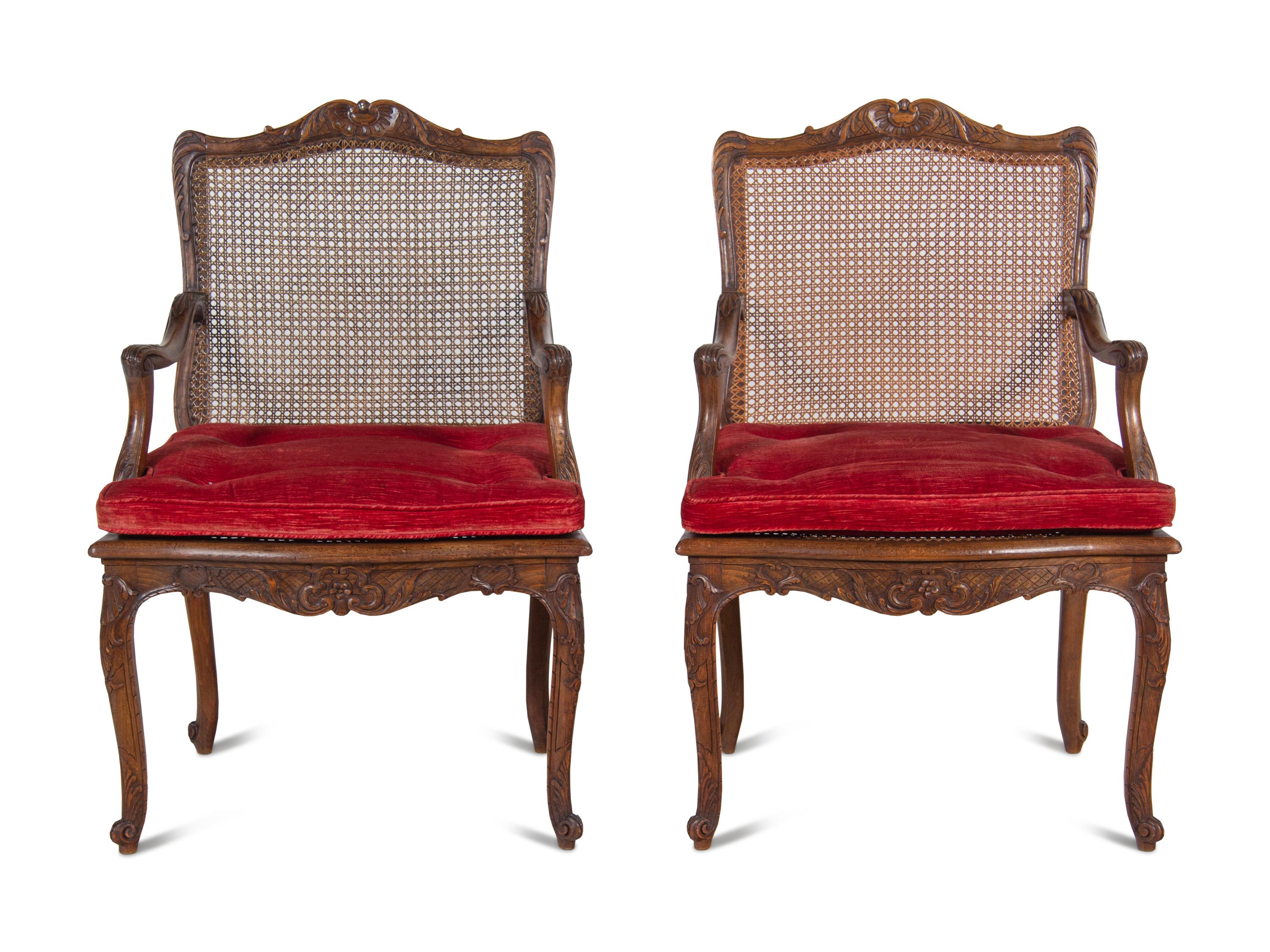 A Pair of Régence Style Carved Walnut and Caned Fauteuils à la Reine