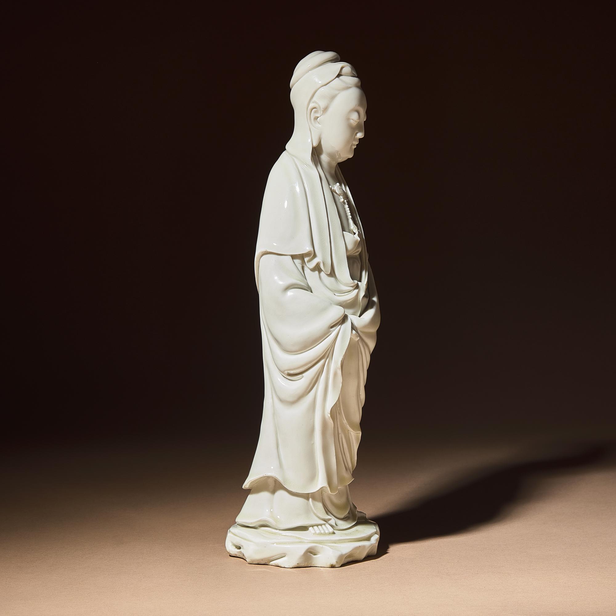 A Chinese Blanc-de-Chine Porcelain Standing Figure of Guanyin with 'He Chaozong' Mark, Qing Dynasty — 清 何朝宗款德化白瓷觀音立像
