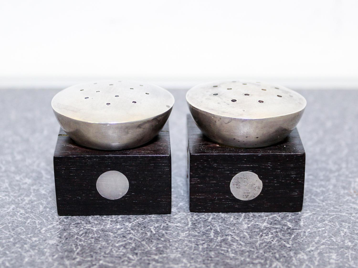 A Pair of Mexican Silver and Rosewood Castors, William Spratling, Taxco, the square ebony base with inset silver discs with a pierced s