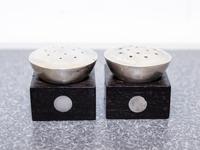 A Pair of Mexican Silver and Rosewood Castors, William Spratling, Taxco, the square ebony base with inset silver discs with a pierced s