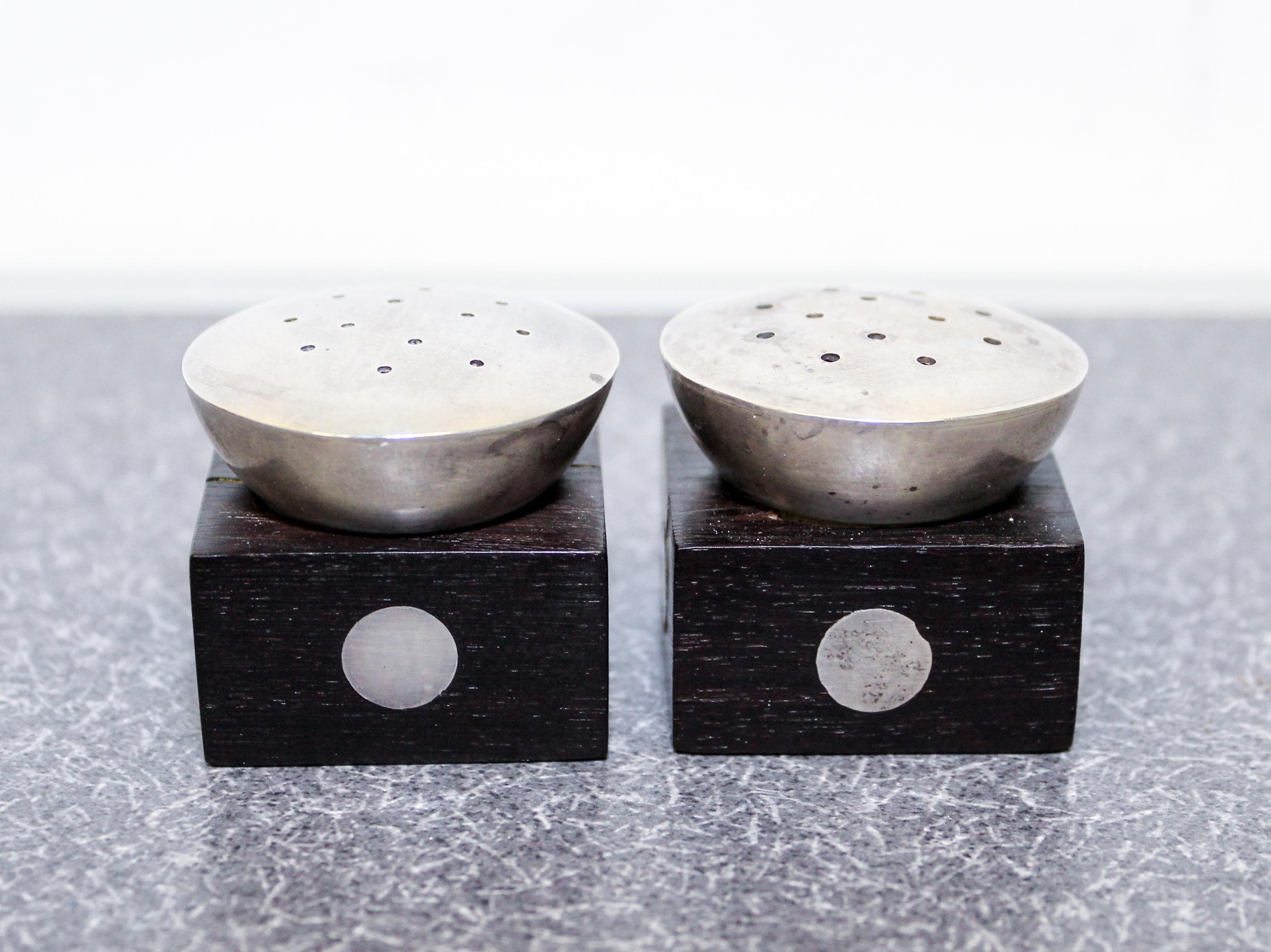 A Pair of Mexican Silver and Rosewood Castors, William Spratling, Taxco, the square ebony base with inset silver discs with a pierced s