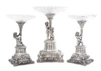 A German Silver and Wheel Cut Glass Three-Piece Figural Garniture, Late 19th Century, each standard modeled as two putti or a putto hol