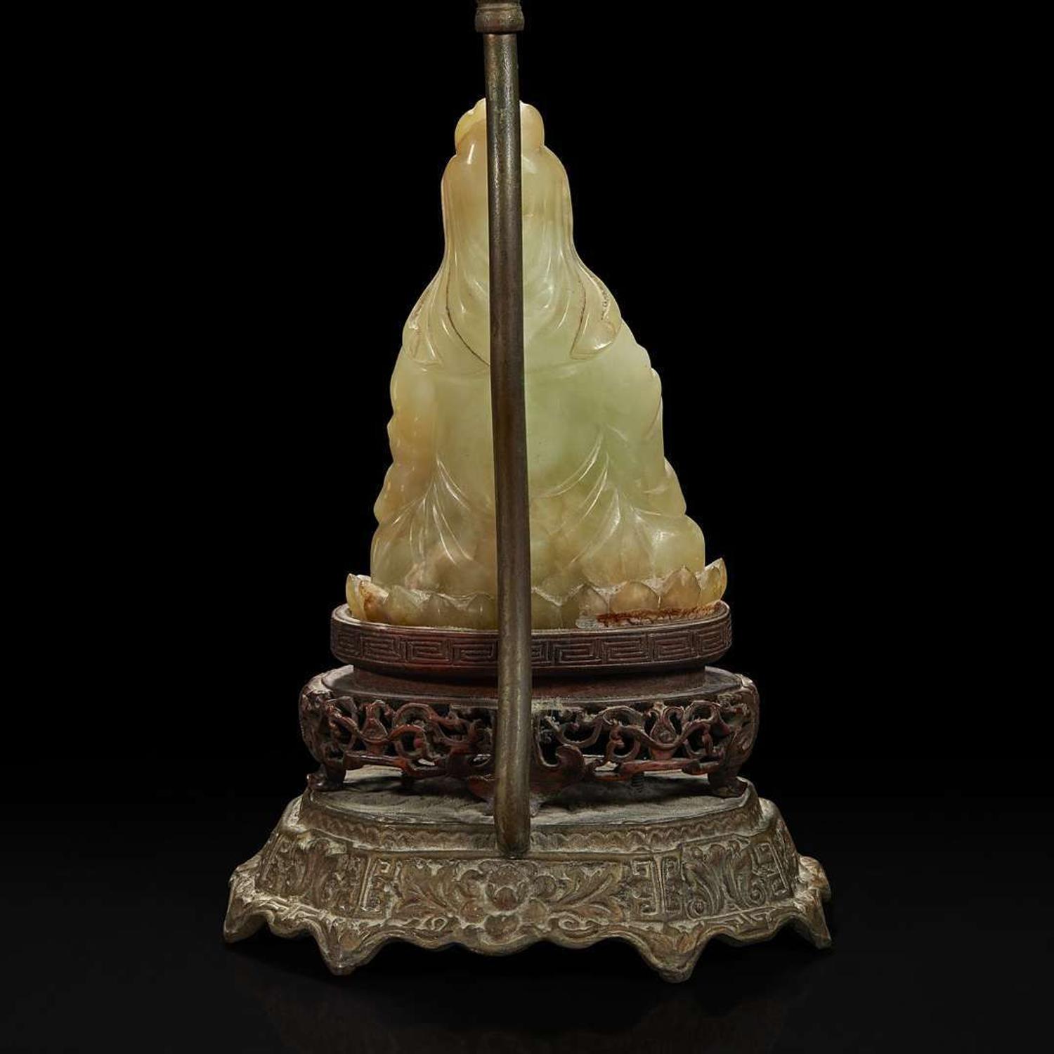 A Chinese carved mottled celadon jade figure of Guanyin, mounted as a lamp 玉雕观音改装台灯