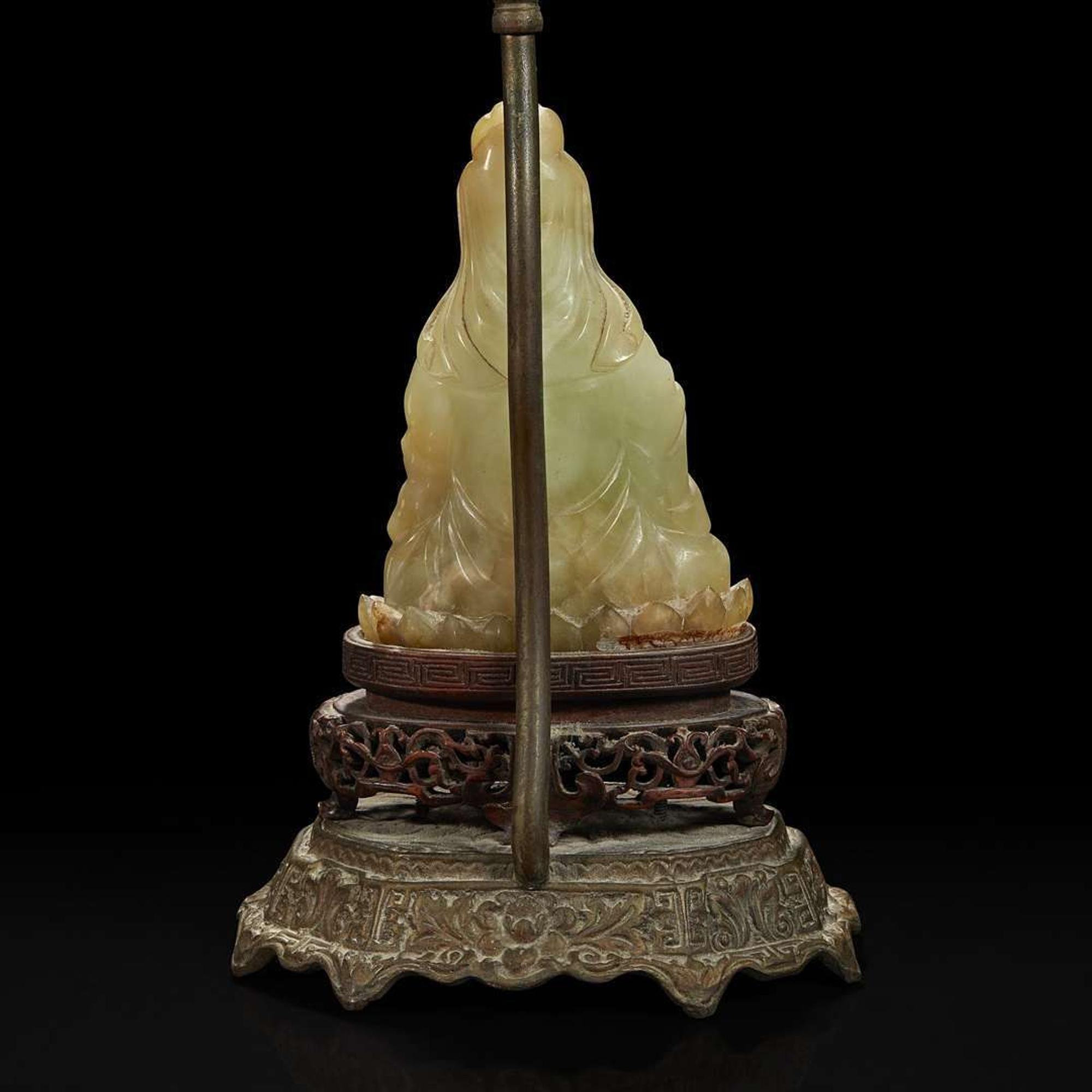 A Chinese carved mottled celadon jade figure of Guanyin, mounted as a lamp 玉雕观音改装台灯
