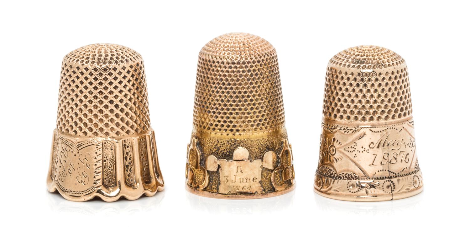 Three Yellow Gold Thimbles, , each having a knurled top and body, one example with a trefoil decorated band to the base, one example en
