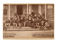 [LITTLE BIGHORN]. Cabinet card group portrait of 17th Infantry officers and their female friends relaxing just prior to setting out on the 1876 campaign.
