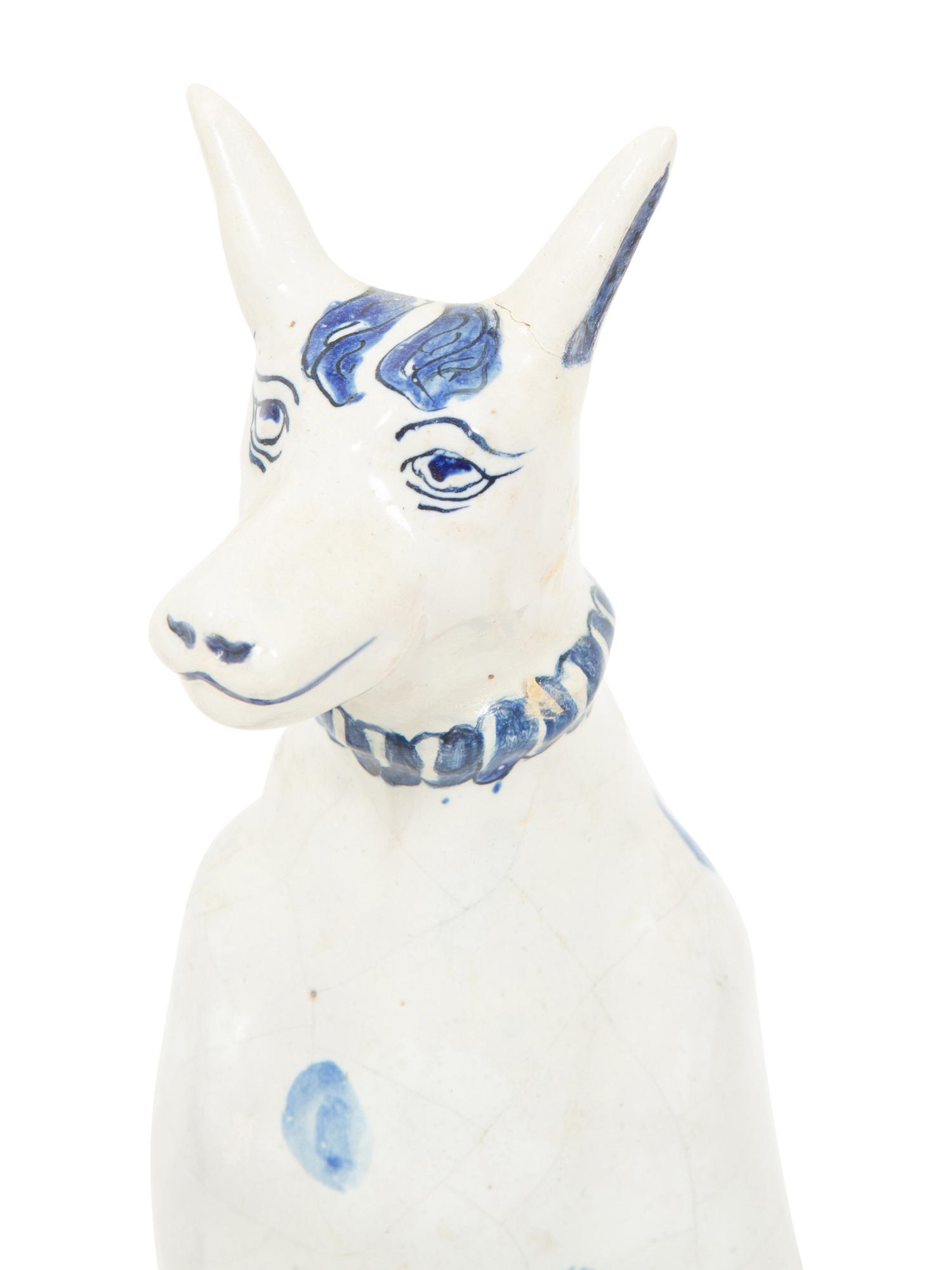 A Delft Blue and White Seated Dog and a Recumbent Cow
