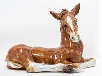 An Italian Ceramic Figure of a Recumbent Foal. Length 30 1/2 inches.