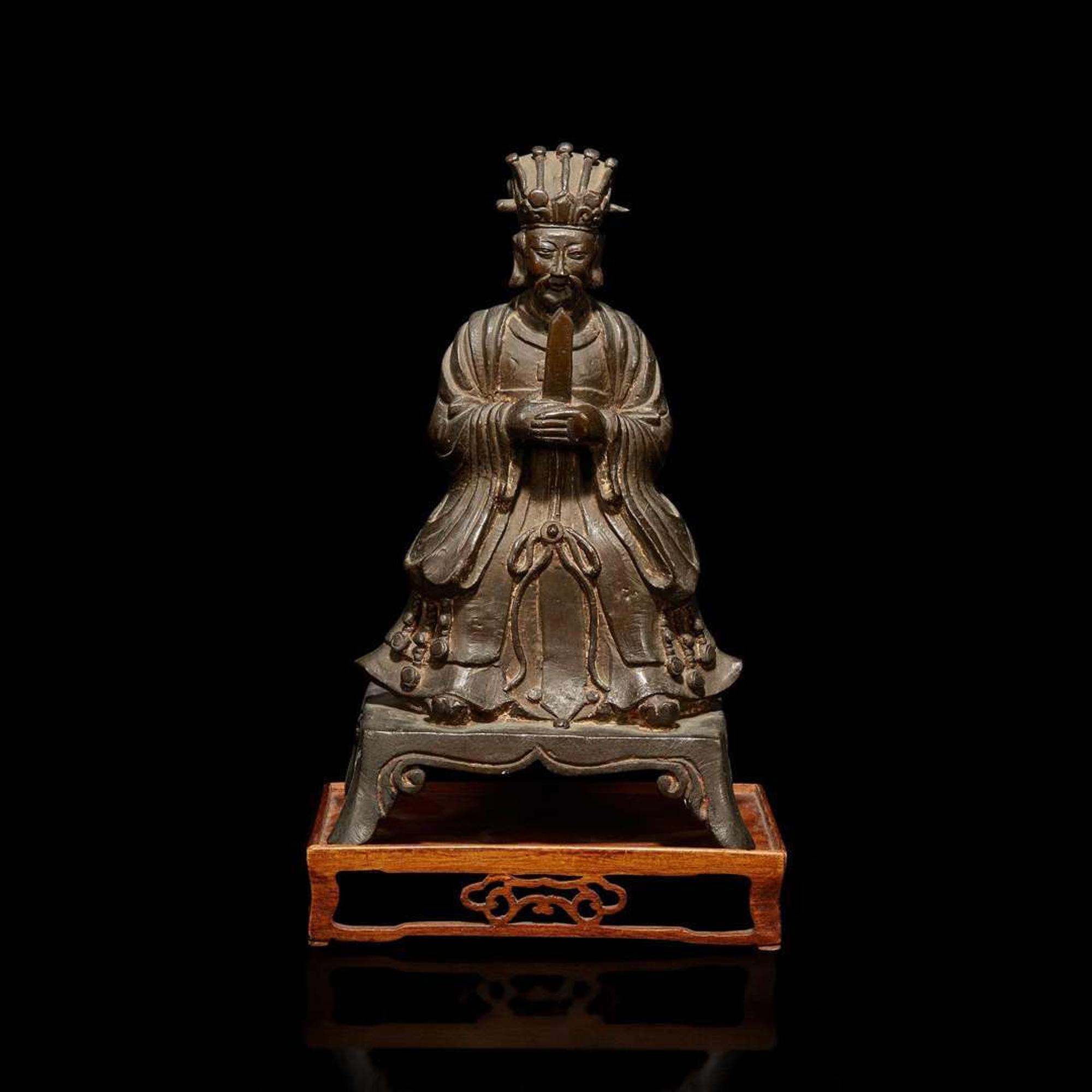 A Chinese bronze figure of a seated Daoist immortal with wood stand 道教仙人銅像與木底座 Ming dynasty ?