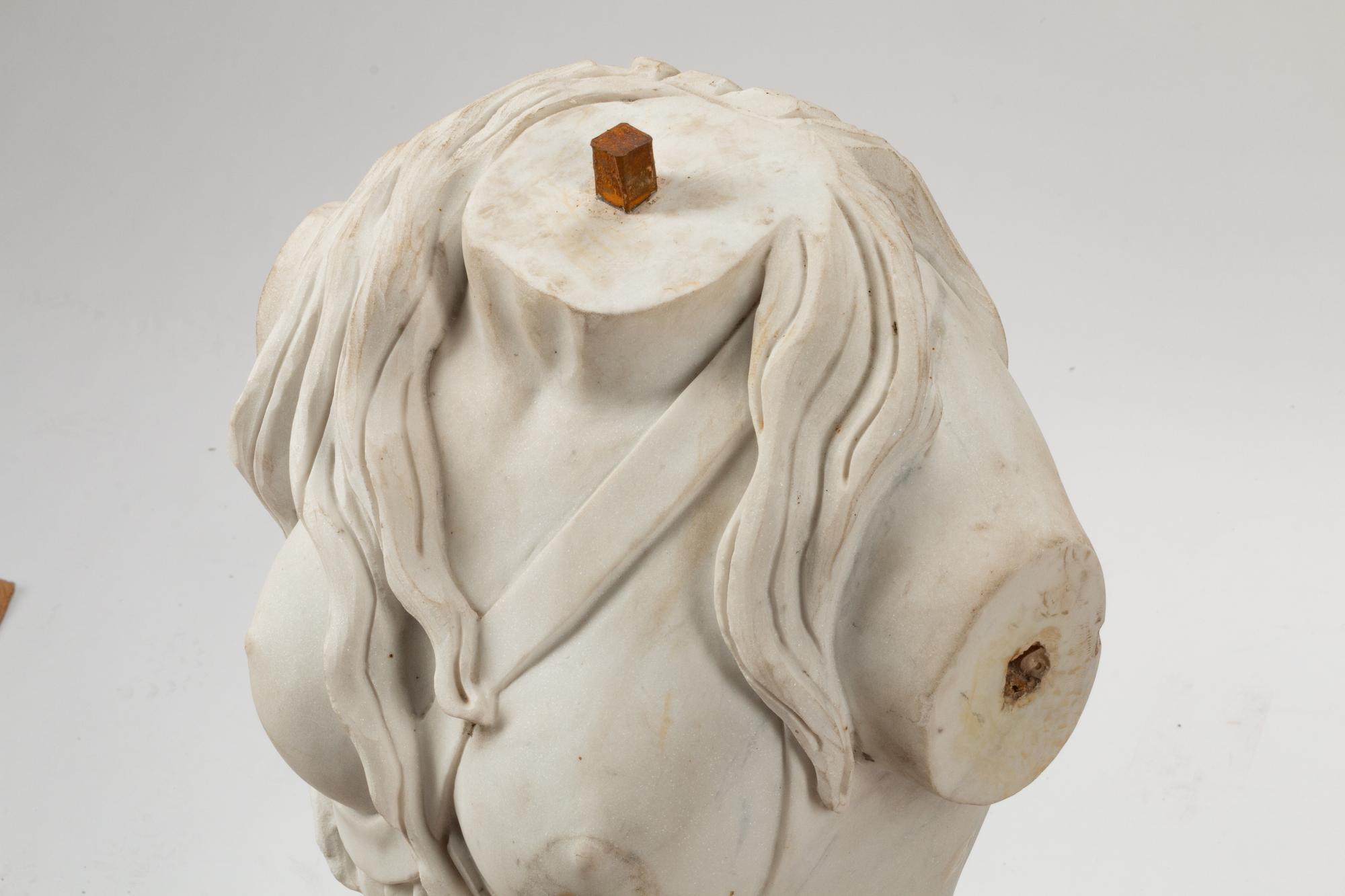 An Italian Carved White Marble Female Torso on an Iron Base