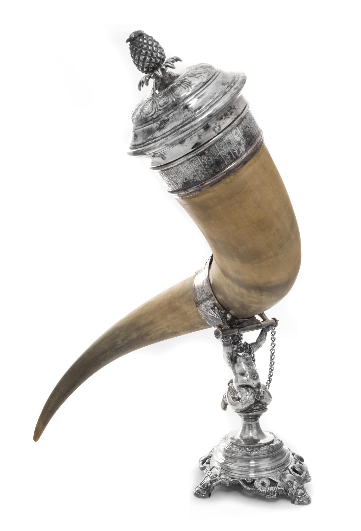 A Continental Silver-Plate Mounted Toasting Horn, , the lid with a pine cone finial, the horn supported by an aquatic putto and raised