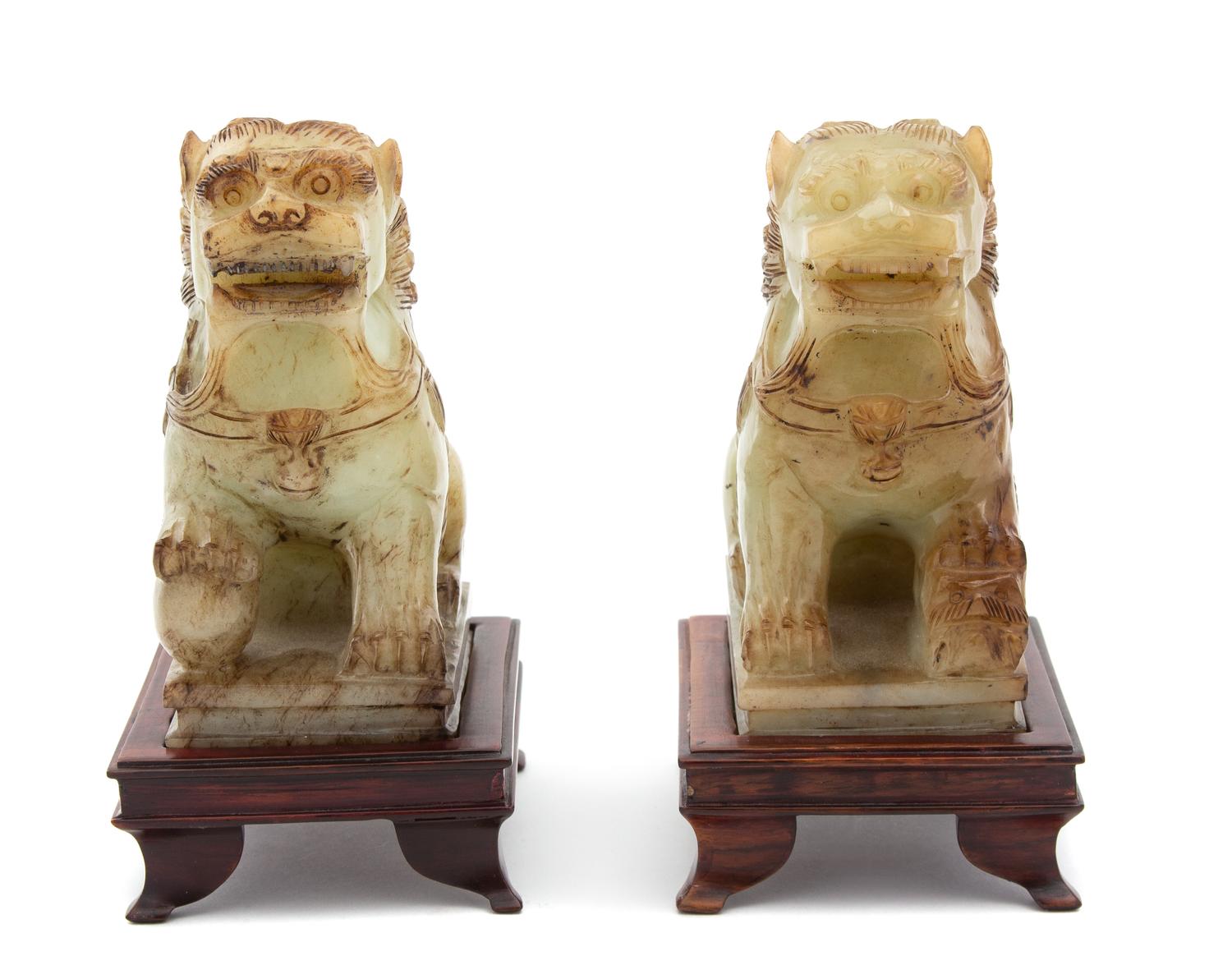 A Pair of Apple Green Jadeite Foo Lions Height 5 inches. — 20TH CENTURY
