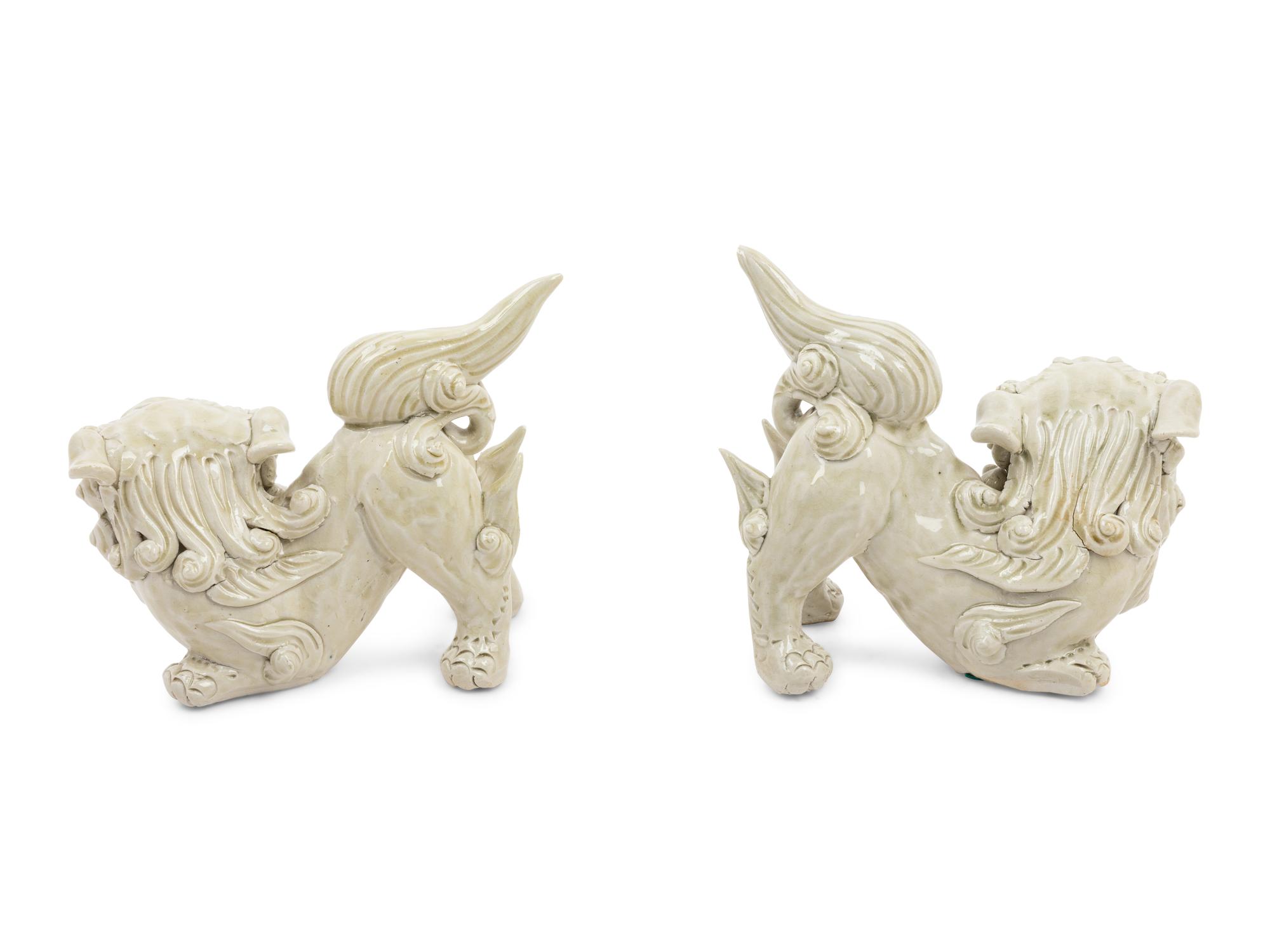A Pair of Chinese White Glazed Porcelain Figures of Fu Lions