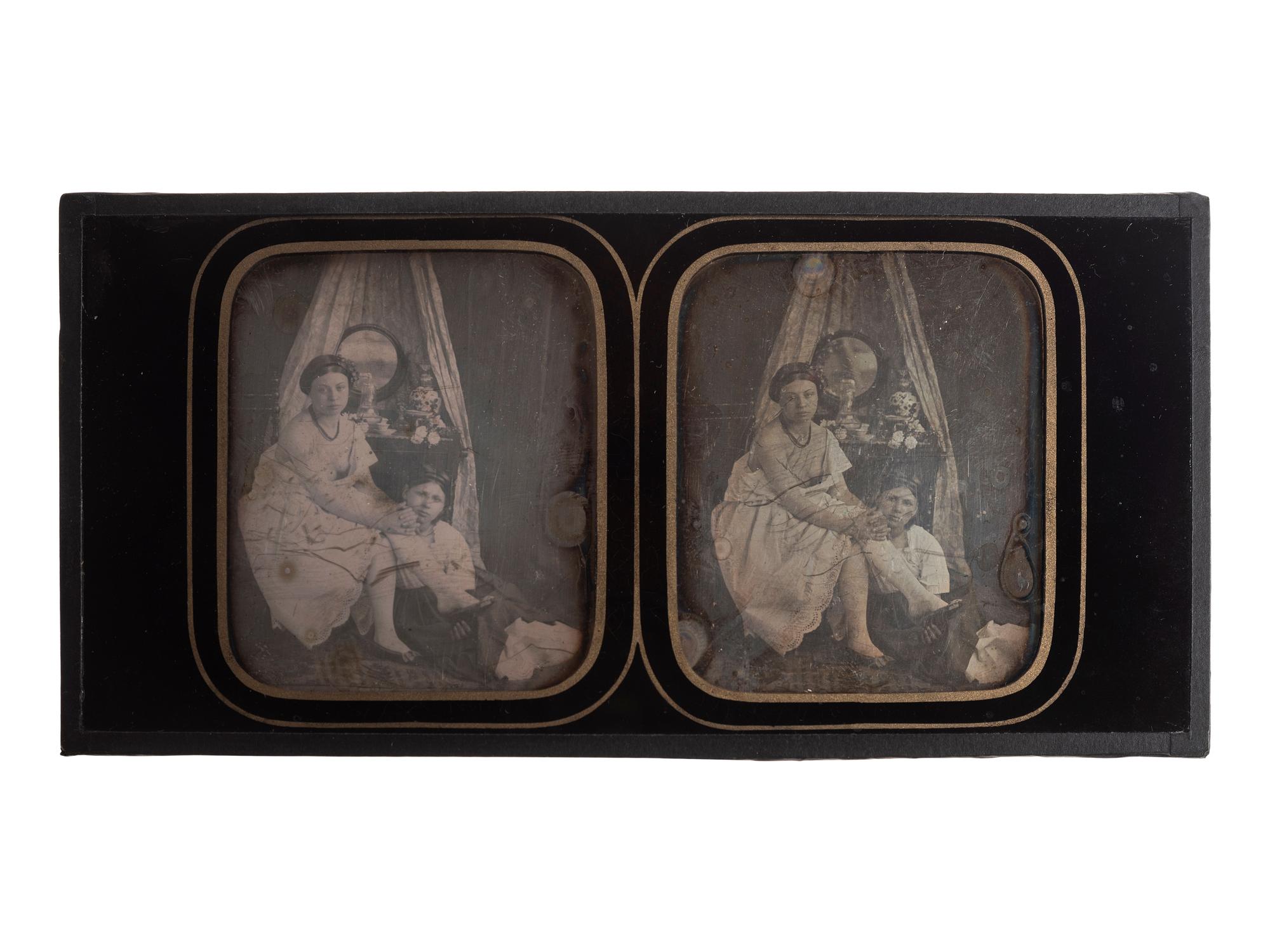 [EARLY PHOTOGRAPHY]. Stereodaguerreotype boudoir scene featuring two young women seated near a vanity.