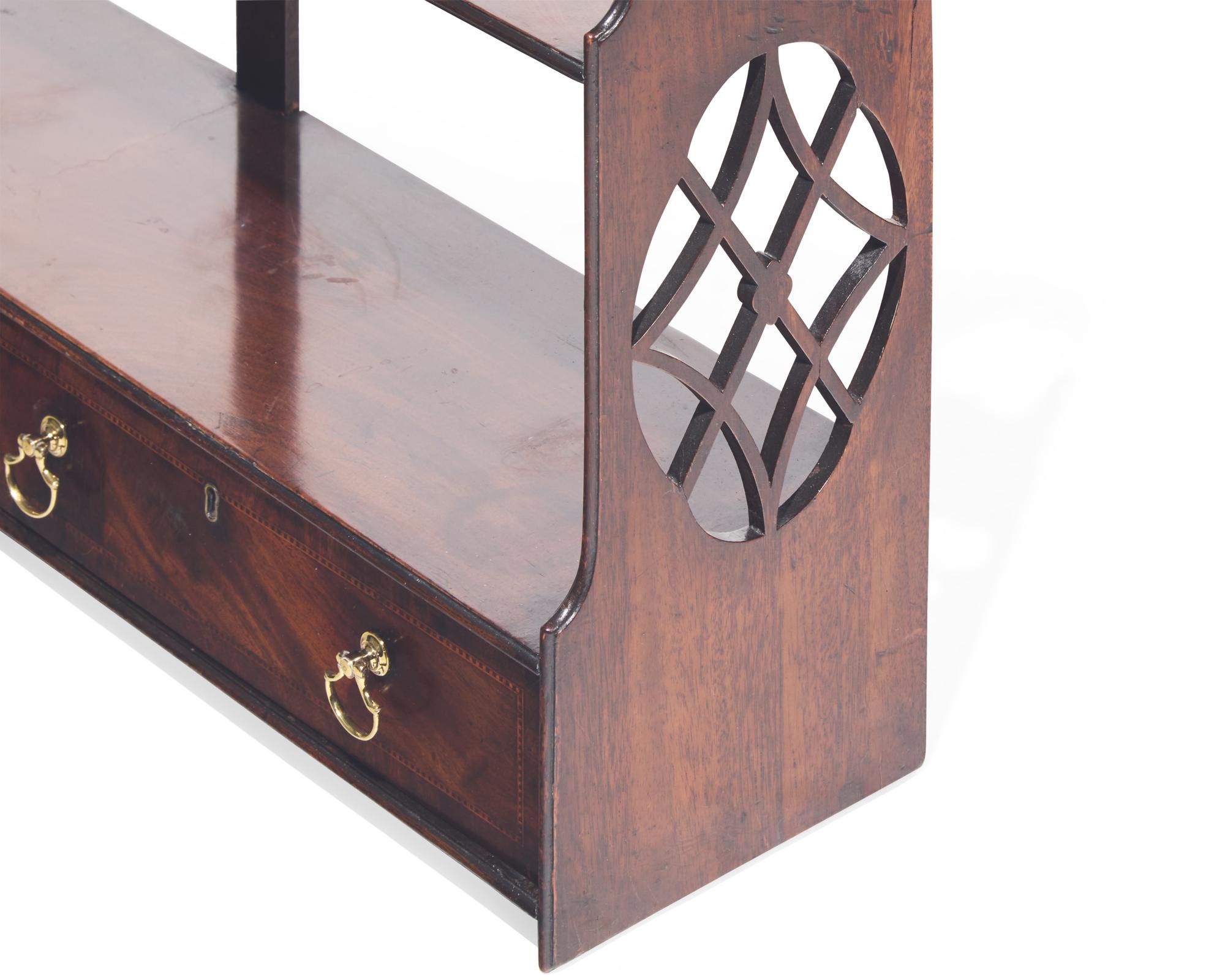 A George III fret-carved and inlaid mahogany hanging wall shelf, circa 1785