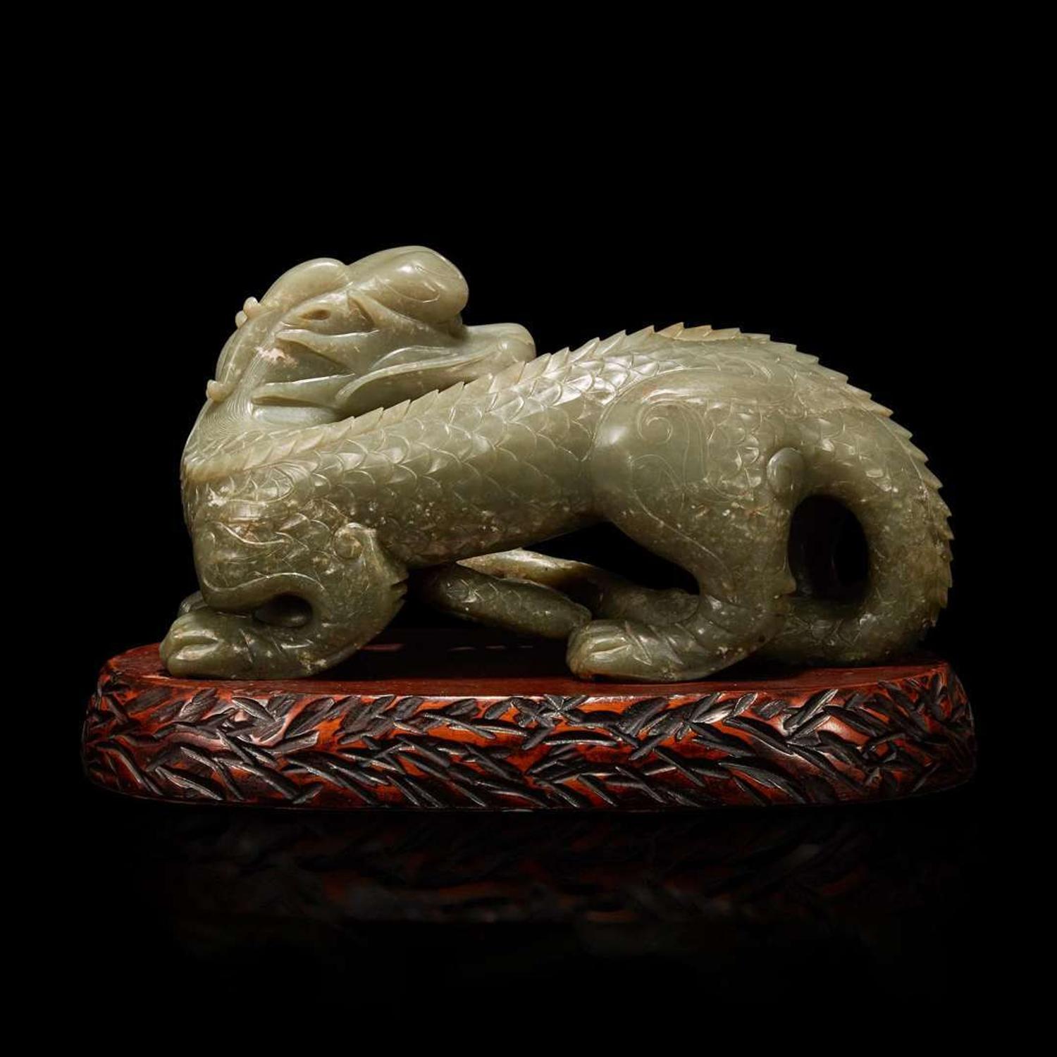 A Chinese carved celadon-grey jade dragon and wood stand 青灰玉龍及木底座