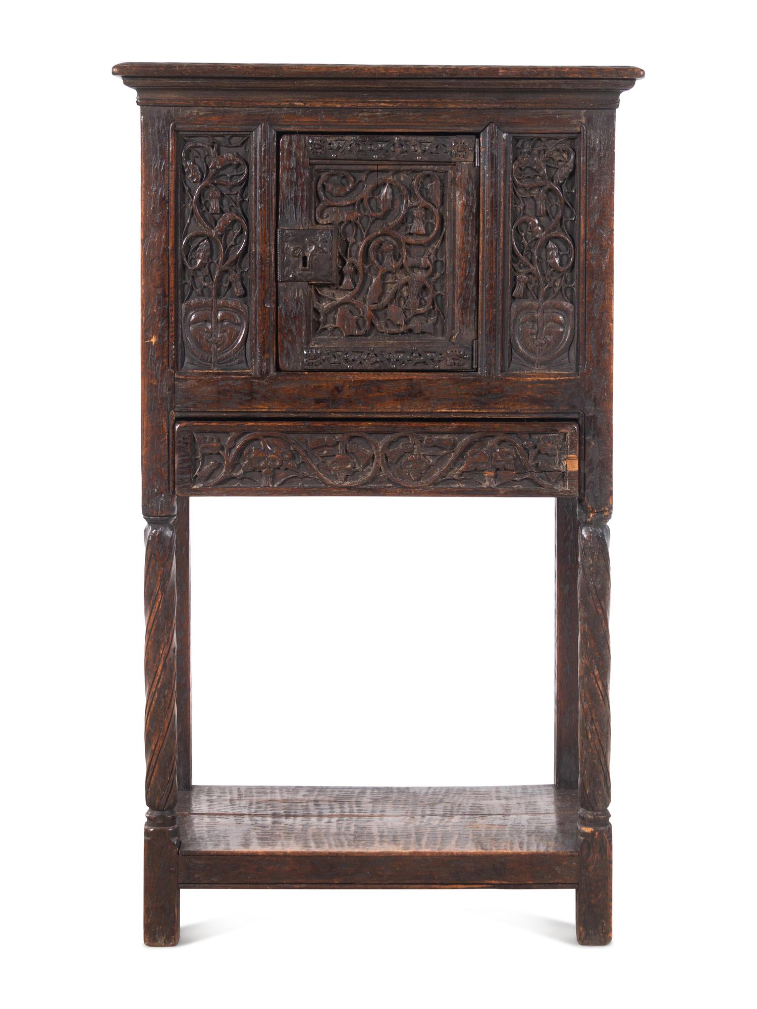 A Gothic Revival Carved Oak Cabinet on Stand