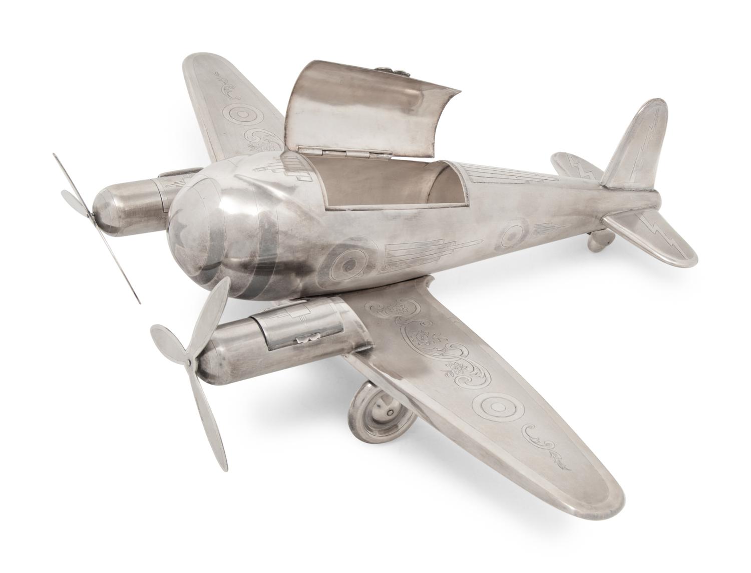 A Large Silvered Metal Airplane-Form Table Top Smoking Set