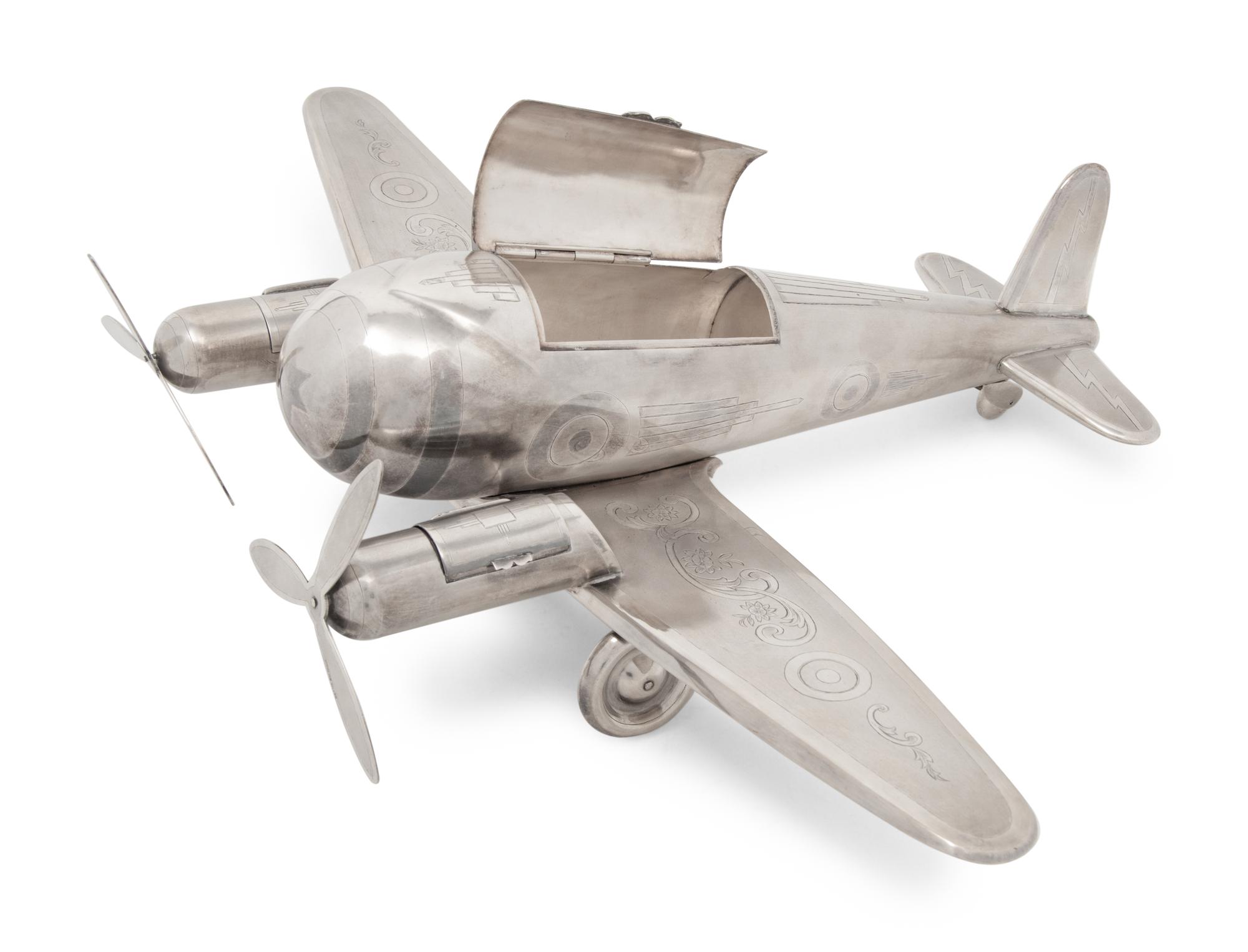 A Large Silvered Metal Airplane-Form Table Top Smoking Set