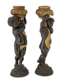 A Pair of Parcel Gilt Cast Metal Putti Candlesticks