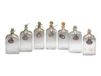 Fifteen Glass Decanters with English Shell-Form Silver Bottle Tags