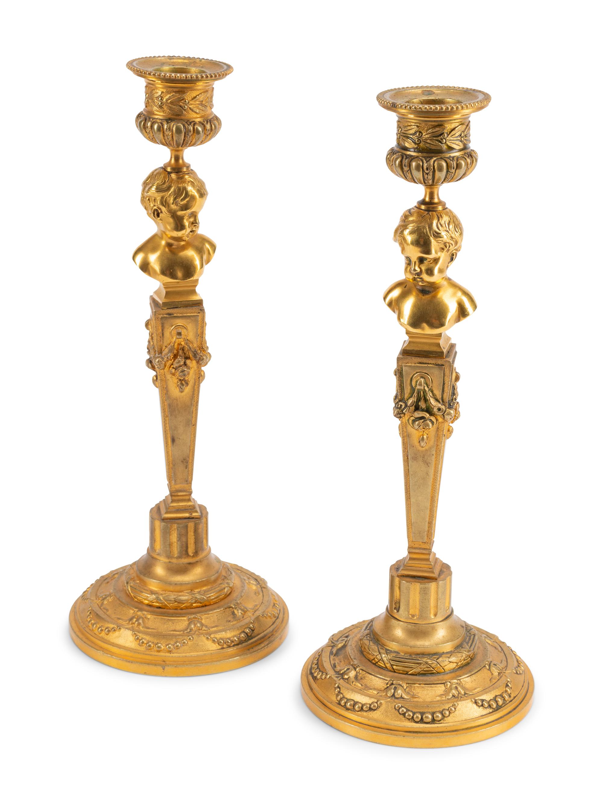 A Pair of Continental Gilt Metal Candlesticks with Busts of Children