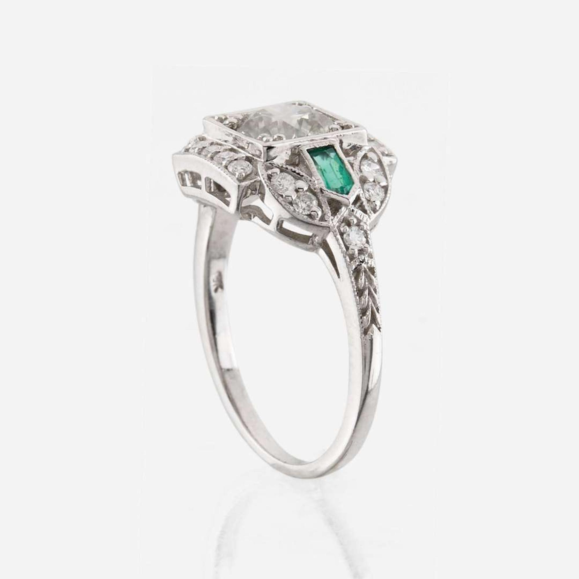 A diamond, emerald, and white gold ring