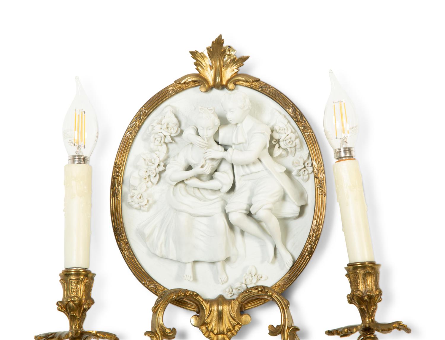 A Pair of Continental Plaster Relief Medallion and Gilt Bronze Two-Light Sconces