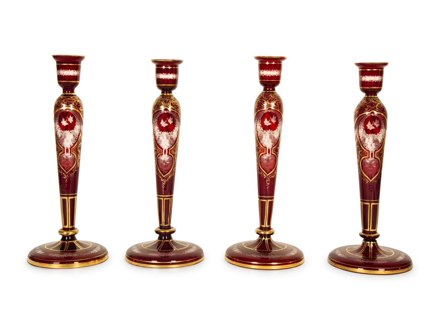 A Set of Four Bohemian Ruby Cut-to-Clear Glass Candlesticks with Gilt Decoration. — 19th Century