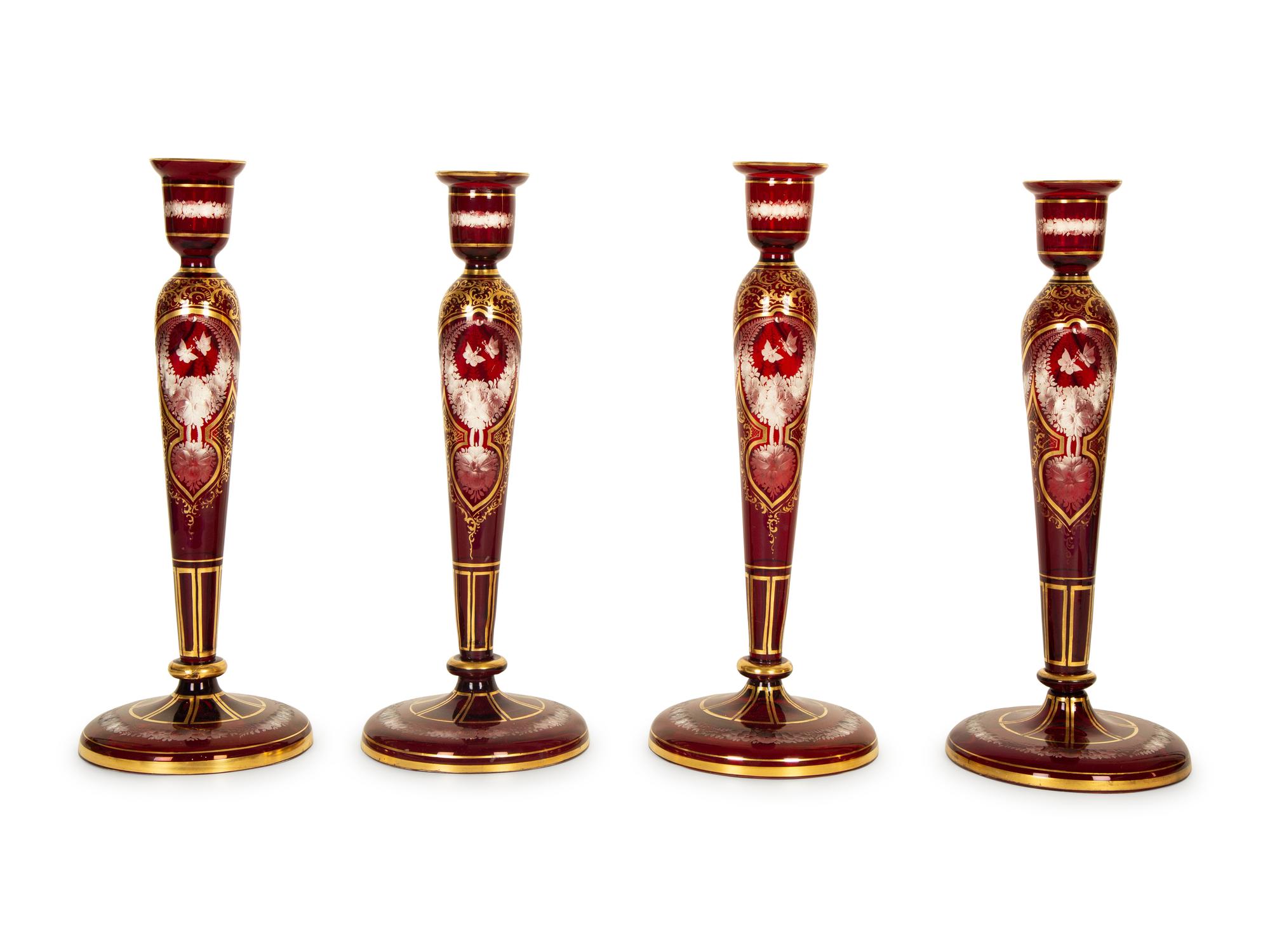 A Set of Four Bohemian Ruby Cut-to-Clear Glass Candlesticks with Gilt Decoration. — 19th Century