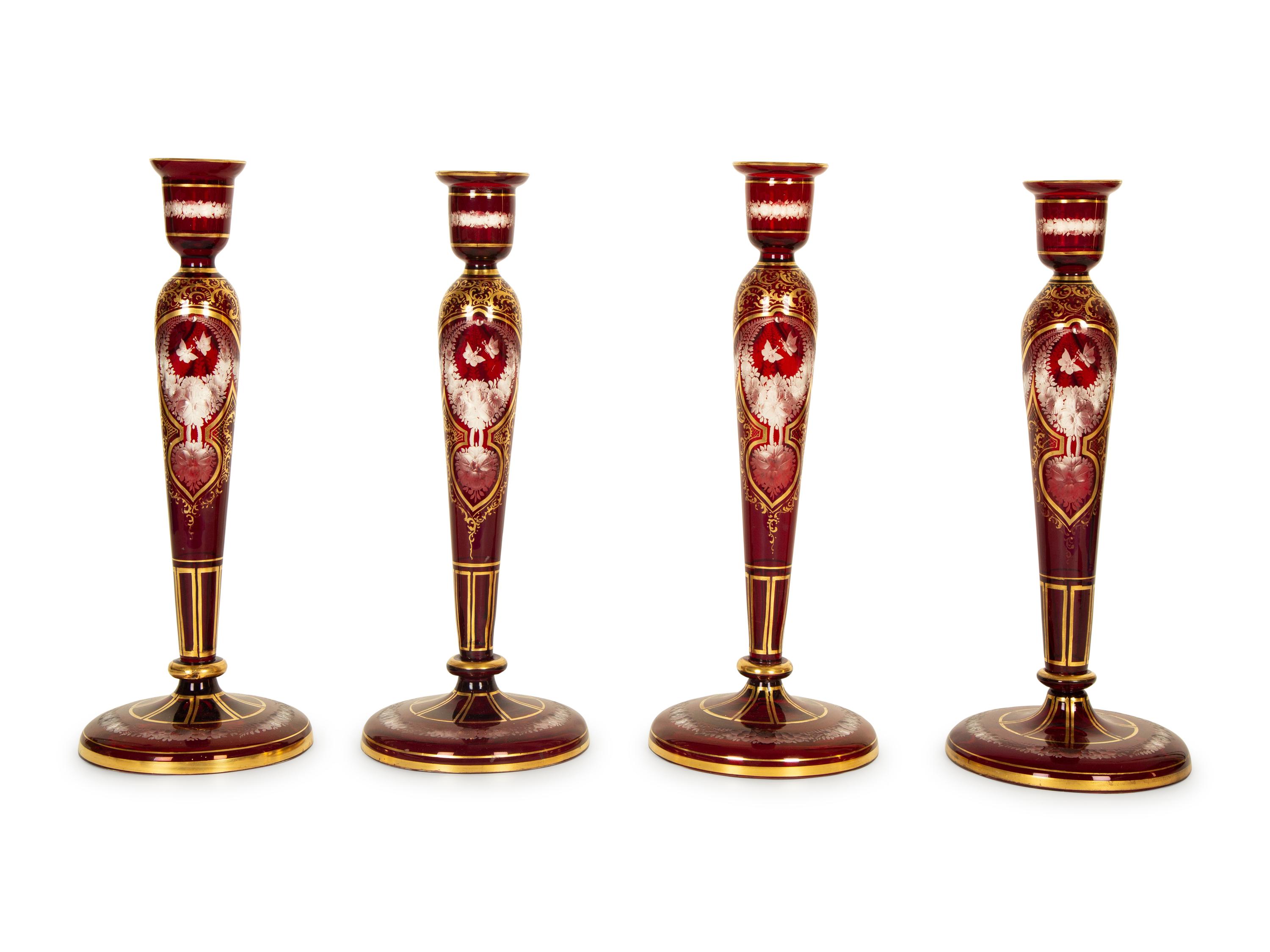 A Set of Four Bohemian Ruby Cut-to-Clear Glass Candlesticks with Gilt Decoration. — 19th Century