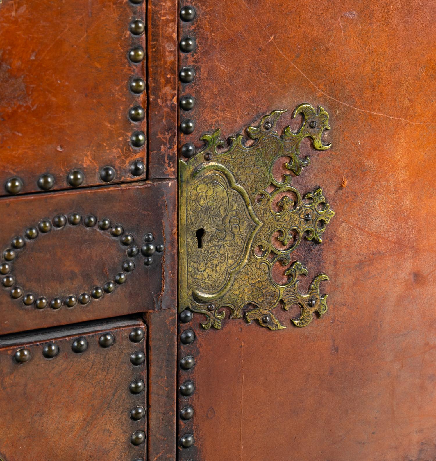 A Spanish Baroque Style Leather-Veneered Side Cabinet