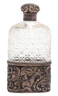 An English Silver Mounted Hip Flask, Finnigans Ltd., Manchester, having a cut glass bottle mounted in a silver base with silver top.