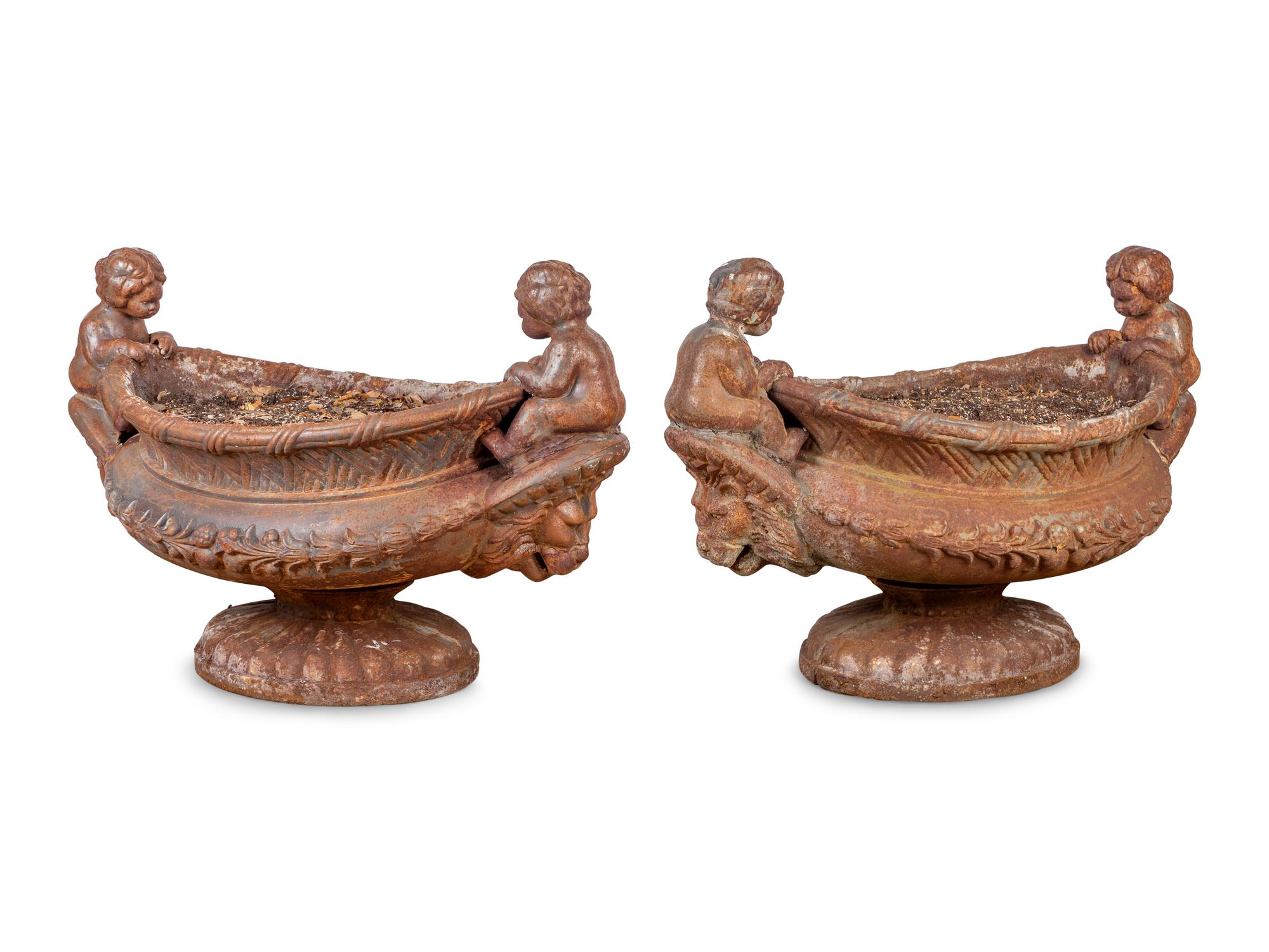 A Pair of Case Iron Oval Footed Planters with Cherub Handles — 20TH CENTURY