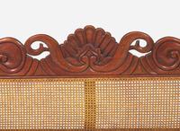 An Anglo-Colonial carved hardwood and caned sofa, first half 19th century