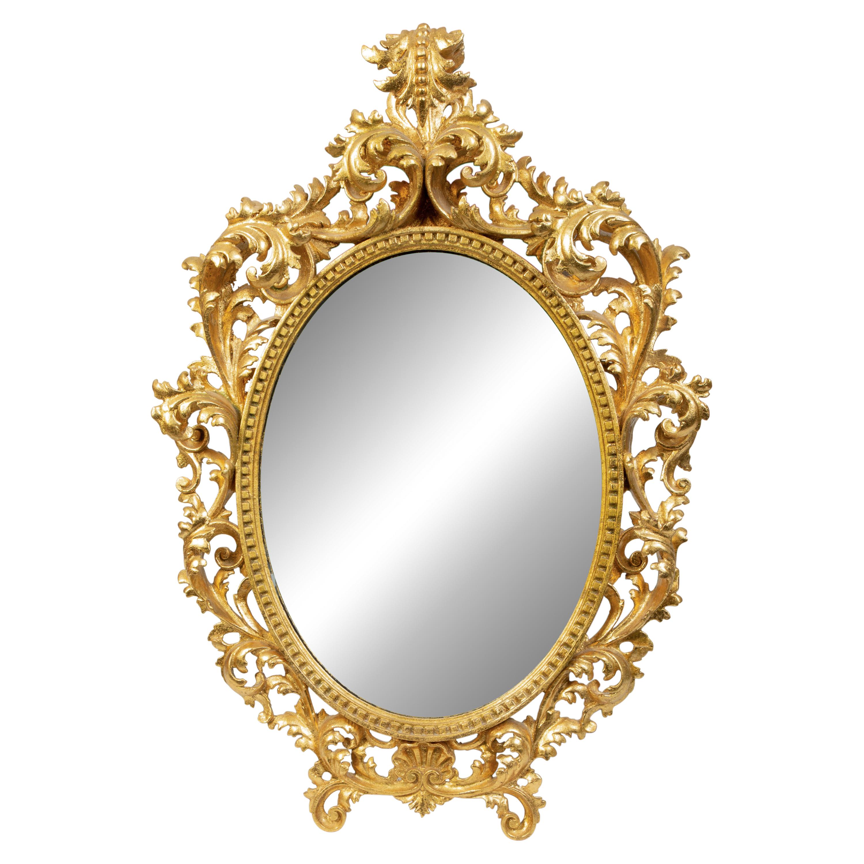 An Italian Rococo Style Carved Giltwood Oval Mirror and a Pair of Wall Brackets