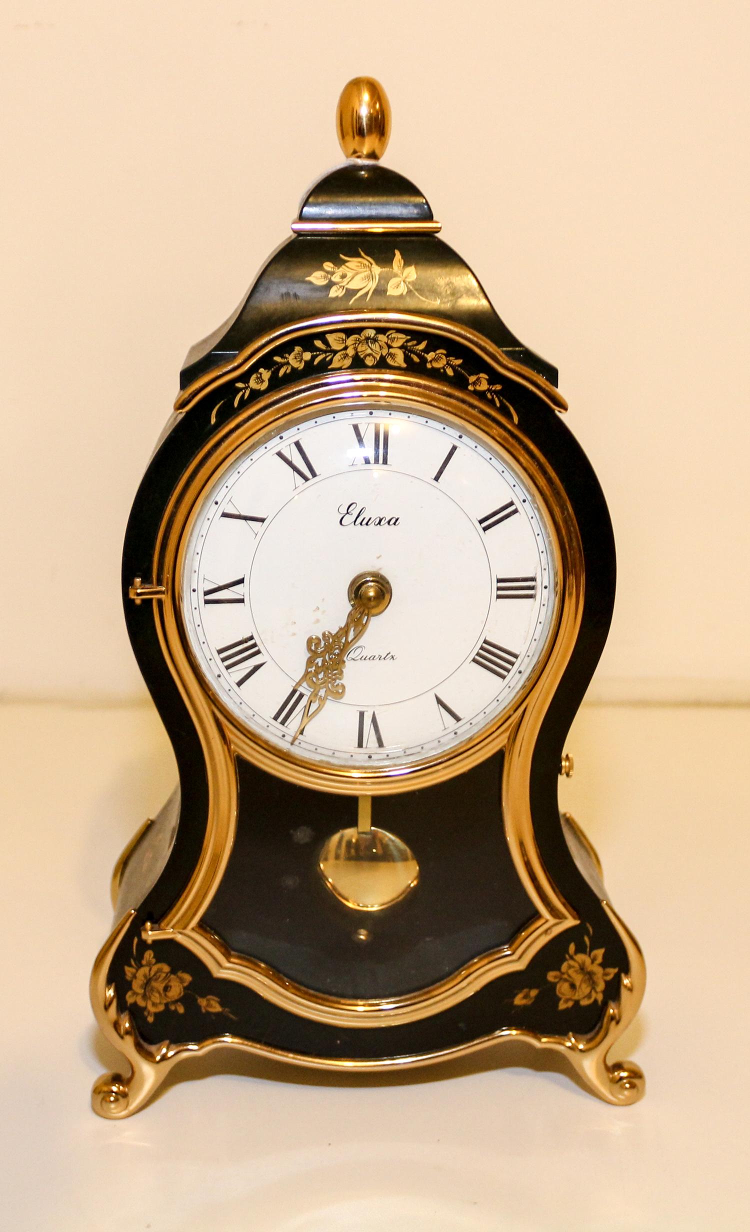 A Gilt Decorated Ebonized Mantel Clock. Height 12 1/2 inches.