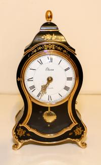 A Gilt Decorated Ebonized Mantel Clock. Height 12 1/2 inches.