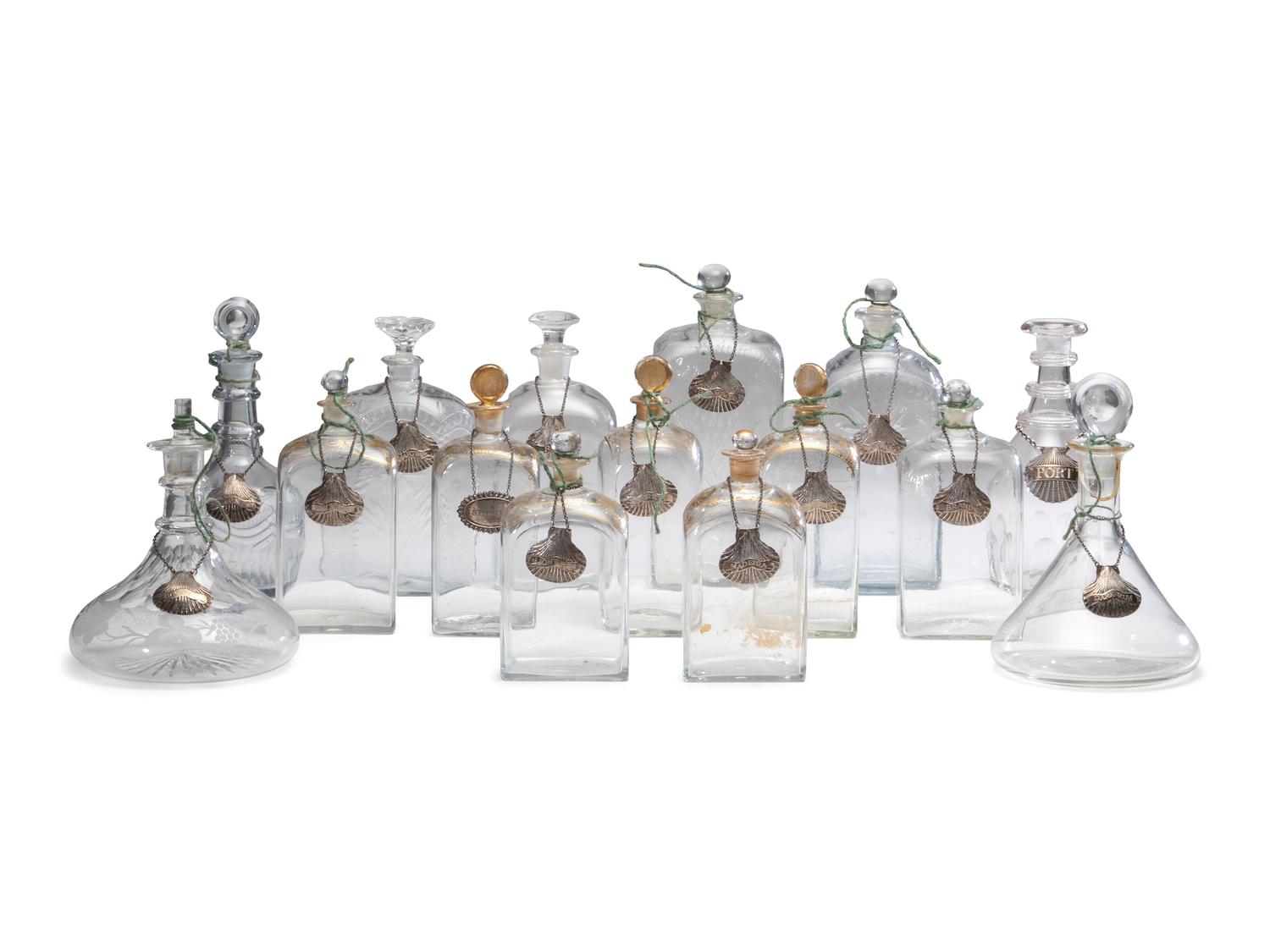 Fifteen Glass Decanters with English Shell-Form Silver Bottle Tags