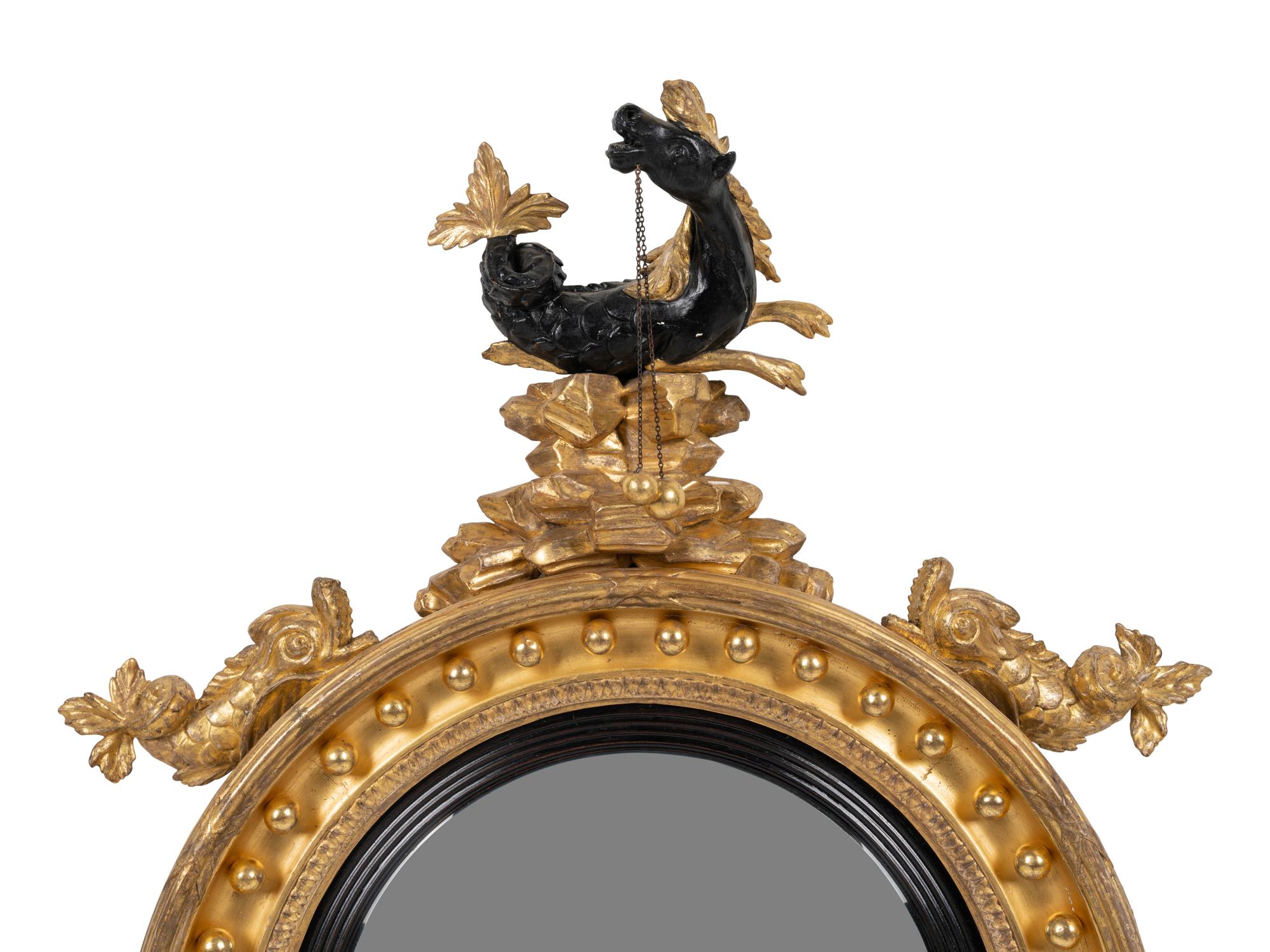 A Regency Parcel Ebonized Giltwood Convex Girandole Mirror